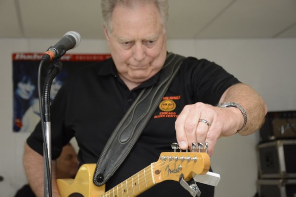 Bob Dunkirk tunes his yellow rhythm guitar. JD ALLEN