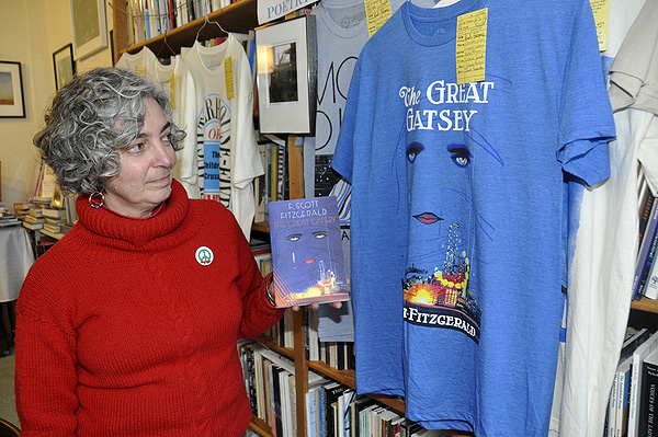 Maryann Calendrille compares "The Great Gatsby" to its T-shirt counterpart, which features the first-edition book cover. MICHELLE TRAURING