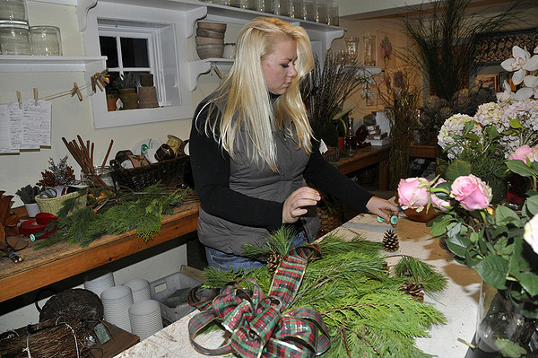 Lindsy puts the finishing touches on a holiday decoration at Sag Harbor Florist. MICHELLE TRAURING