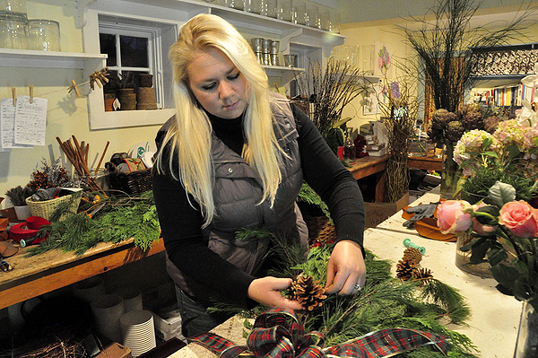 Lindsy puts the finishing touches on a holiday decoration at Sag Harbor Florist. MICHELLE TRAURING