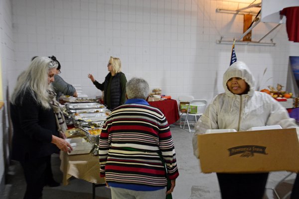 Nashota Smith, a member of the Shinnecock Youth Council, carries a box full of meals meant for elders who couldn't make the festivities. JD ALLEN