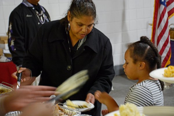 Aiyana Smith-Williams teaches Kellis Quinn, 6, how to prepare a plate for the ancestors as part of a food ceremony. JD ALLEN