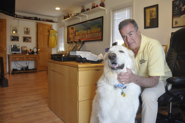 Richie Russek with his dog, Mountain, at Grey Flannel headquarters in Westhampton Beach. MICHELLE TRAURING
