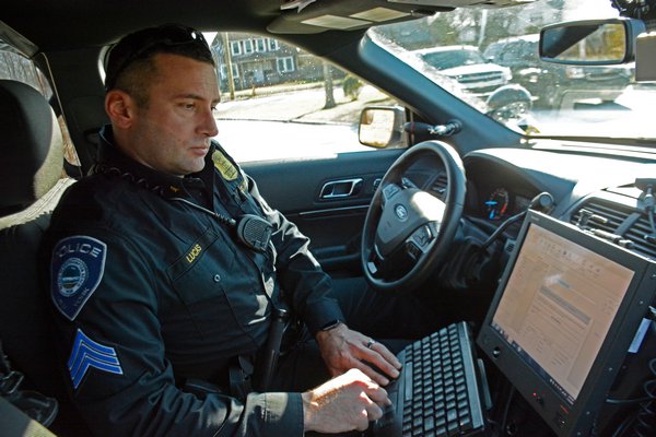 Sergeant Ryan Lucas of the Westhampton Beach Police Department fills out an accident reports on a computer in his patrol car through a law enforcement software, which sends data directly to the police station and the DMV. JD ALLEN