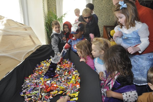 Trick-or-treaters grab a handful of candy at the Corwith House in Bridgehampton. MICHELLE TRAURING