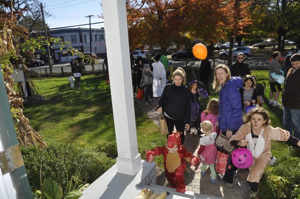 Trick-or-treaters race up the steps of the William Corwith House in Bridgehampton. MICHELLE TRAURING