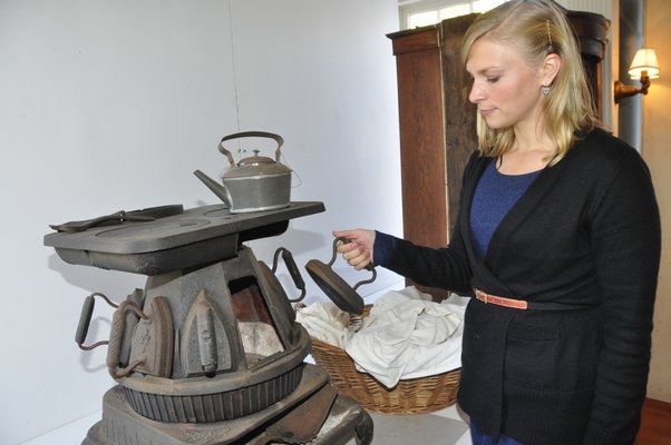 Cast-iron ironing stoves were typically found in Southampton estates, with different weighted irons, one held by Emma Ballou. MICHELLE TRAURING