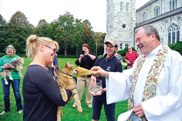 October 10: Father Mike Vetrano of the Basilica of Sacred Hearts of Jesus and Mary in Southampton blesses Mindy Armandi and Noodles at the annual St. Francis Blessing of the Animals on the Great Lawn of the Basilica.