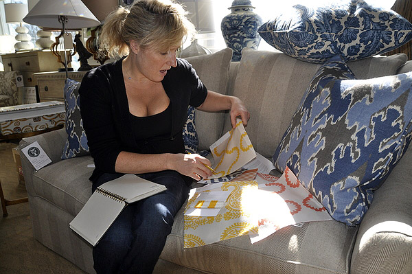 Zoe Hoare sifts through new outdoor pillow fabrics at English Country Antiques in Bridgehampton. MICHELLE TRAURING