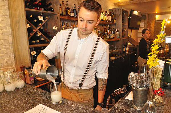 Derek Nielsen makes a Gin Daisy behind the bar at The Cuddy in Sag Harbor. MICHELLE TRAURING
