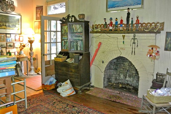 The main room of the house holds the ticket window, the original fireplace and an original bench from the train station.  DANA SHAW