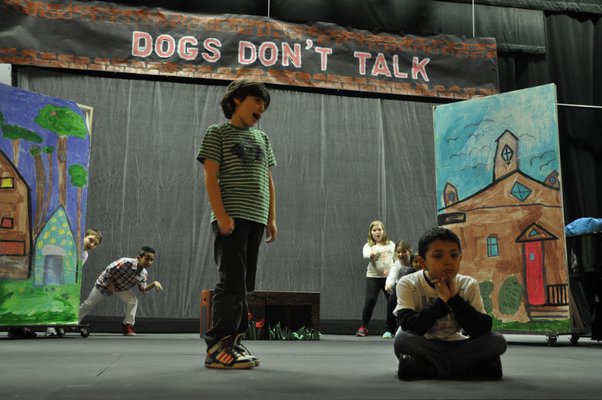 Daniel Piver, left, sings at Santiago Maya while a cast of "dogs" look on during the Springs School Opera Company's production of "Dogs Don't Talk" at Guild Hall in East Hampton. MICHELLE TRAURING