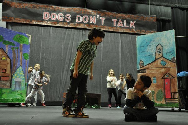 Daniel Piver, left, sings at Santiago Maya while a cast of "dogs" look on during the Springs School Opera Company's production of "Dogs Don't Talk" at Guild Hall in East Hampton. MICHELLE TRAURING