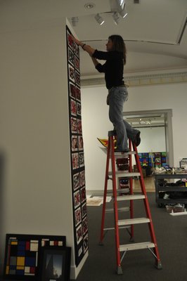 Kerrie Sundara helps install the 22nd annual Student Art Festival Part I at Guild Hall in East Hampton. MICHELLE TRAURING