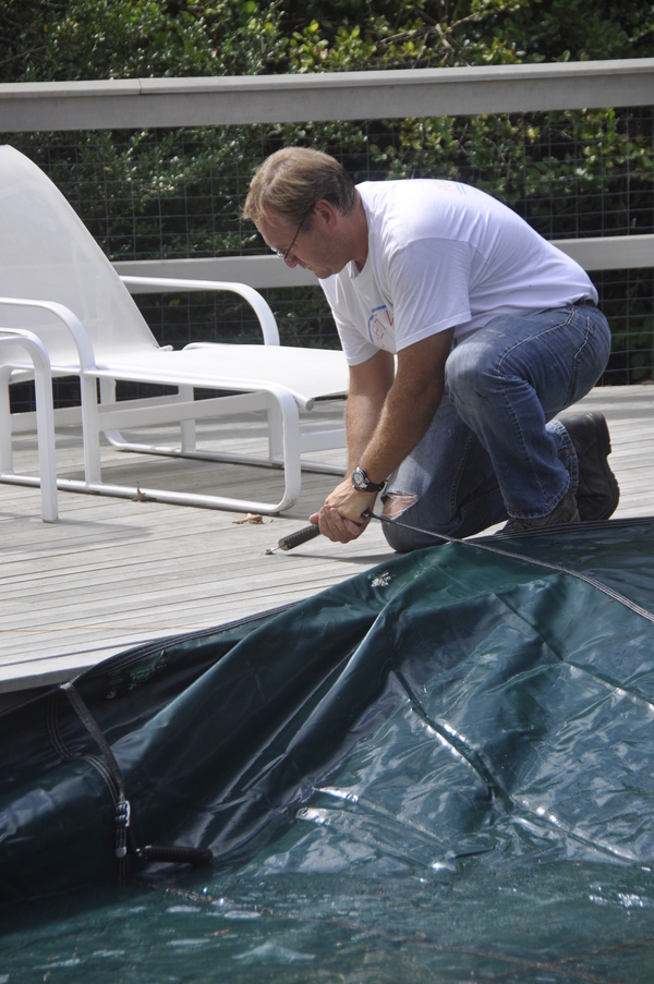 John's Pools & Spas executive manager Stanley Schorr covers a pool in Quogue.