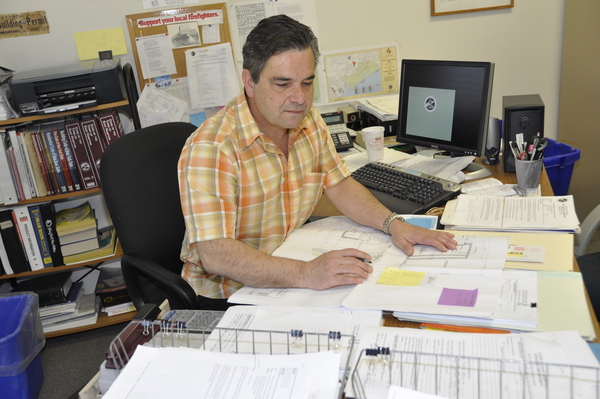 East Hampton Town Senior Building Inspector Tom Preiato works at his office. MICHELLE TRAURING
