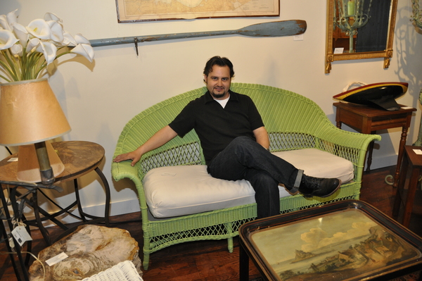 Black Swan Antiques owner Randy Kolhoff lounges on an antique wicker couch at his store in Bridgehampton.