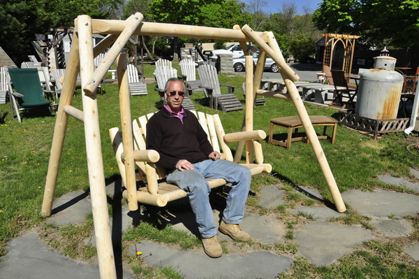 East End Outdoor Supply owner Mark Saladino sits on a white cedar porch swing at his store in East Quogue.