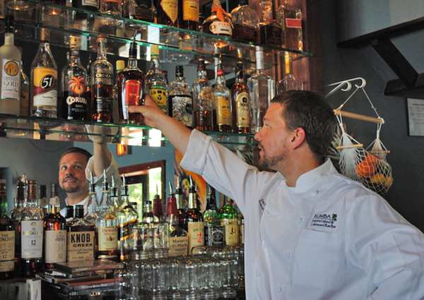Rumba offers 62 kinds or rum at its island-themed restaurant.  Owner David Hersh reaches for a bottle at the indroor bar, above.