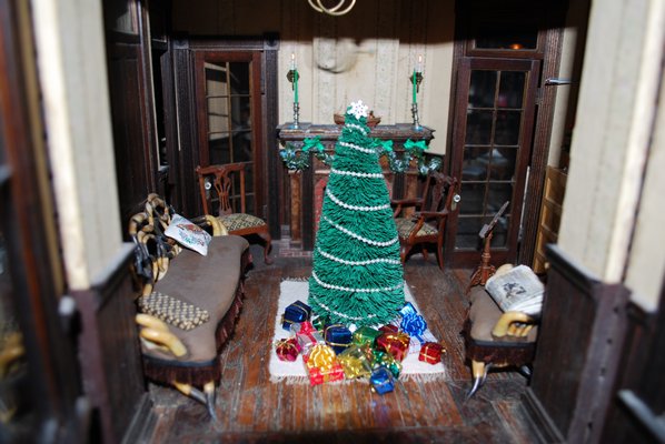 A dollhouse living room decorated for Christmas LAURA WEIR