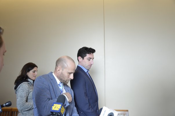Amos Goodman walks out of a courtroom in Central Islip on Wednesday, December 5, with his attorney, Craig Fleischer of the Hauppauge-based law firm of Keahon, Fleischer and Ferrante, after being arraigned on 20 felony counts, and released on his own recognizance. GREG WEHNER