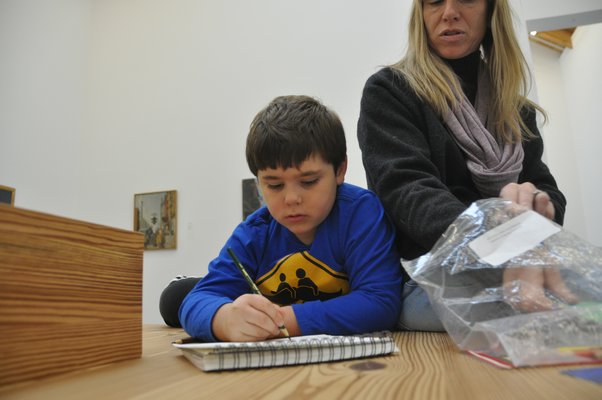 J.P. Carrello draws while his mother, Adrian, looks on. MICHELLE TRAURING