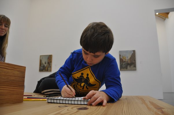 J.P. Carrello draws while his mother, Adrian, looks on. MICHELLE TRAURING