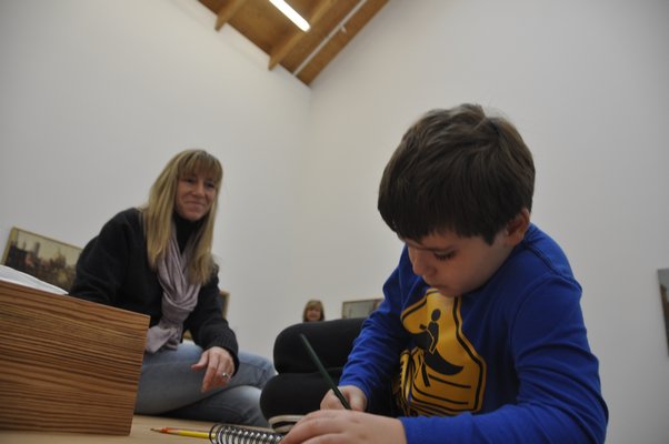 J.P. Carrello draws while his mother, Adrian, looks on. MICHELLE TRAURING