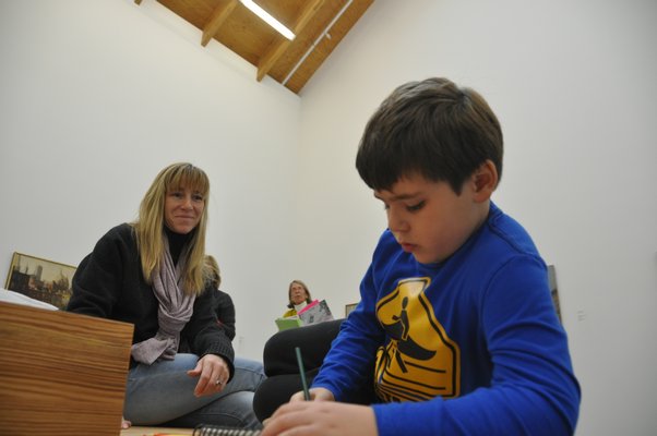 J.P. Carrello draws while his mother, Adrian, looks on. MICHELLE TRAURING