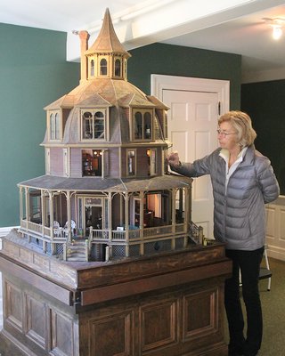 Jean Rickenbach of the East Hamptopn Ladies Village Improvment Society with the dollhouse that now resides in the office.  KYRIL BROMLEY