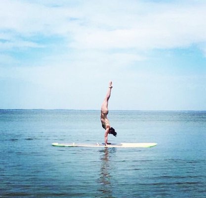 Dana Barre does a handstand on a paddleboard in June of 2017.