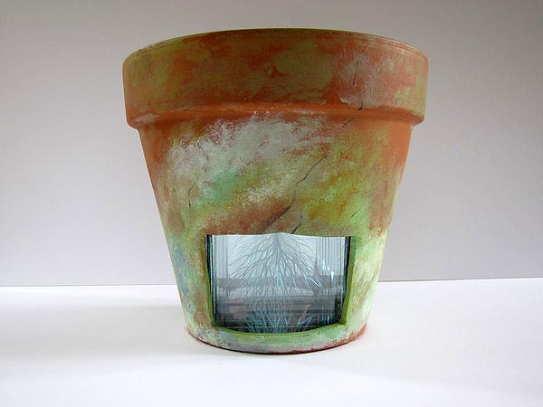 Terra cotta pot by Nicolette Jelen. The glass and mirror insert is etched with tree branches that can be seen through the window in the pot. COURTESY ALEXANDRA EAMES