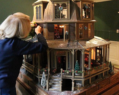 Joan Denny puts the finishing touches on the dollhouse at the East Hampton Ladies Village Improvement Society headquarters.  KYRIL BROMLEY