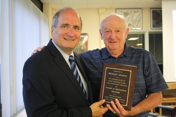 Sag Harbor School Board Trustee Edward Drohan (right) recieves a plaque from Superintendent Dr. Carl Bonuso honoring the end of his three years of service on the board. Brandon B. Quinn