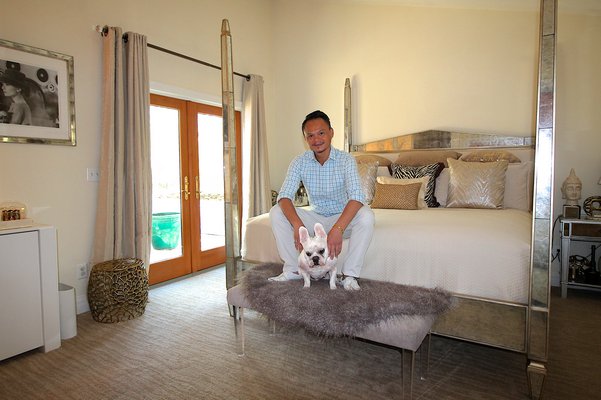Thuyen Nguyen and Wally in the "Asian glam" master bedroom, featuring a mirroed four-poster bed. KYRIL BROMLEY