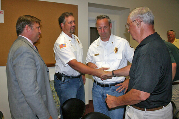 Southamtpon Village Fire Department Chief Roy "Buddy" Wines IV shakes hands with Fire Commissioner Fred Andrews, with Mayor Mark Epley, right, and Fire Department Assistant Chief Rodney "Chip" Pierson looking on.