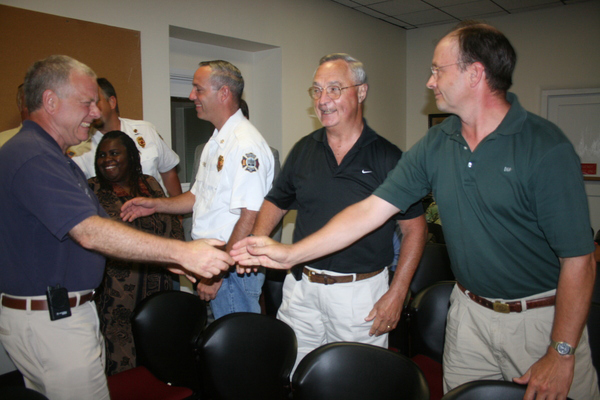 Southampton Village Trustee Paul Robinson shakes hands with Fire Commissioners Fred Andrews, left, and Dave Price.