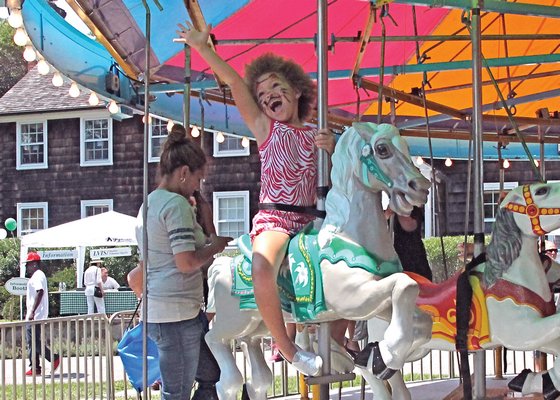 July 31: Kaia Wetzel rides the carousel at the East Hampton Ladies Village Improvement Society’s annual fair.