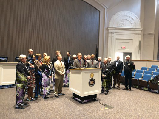 New York State Senator James Gaughran speaking during a rally at Huntington Town Hall calling for the restoration of AIM funding in the state budget. Behind him are various town supervisors and village mayors. COURTESY OFFICE OF ASSEMBLYMAN FRED THIELE