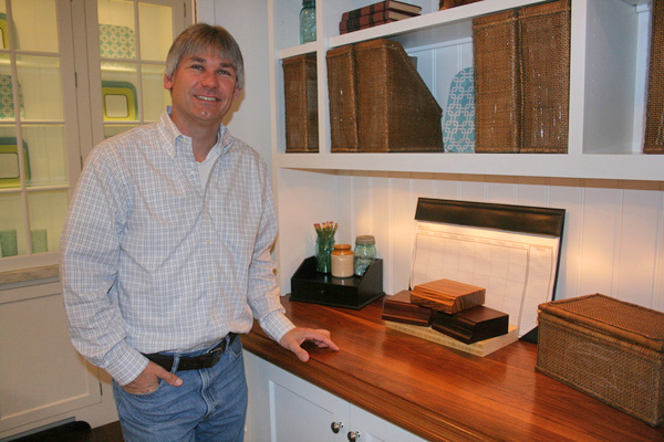 Rich Raffel, owner of E.T. Raffel Cabinets in Southampton, next to a wide-plank walnut countertop, an option for homeowners who want a warmer-feeling kitchen.