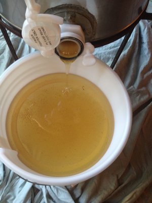 From the extractor, the honey flows into a screened bucket to strain out bee bits and other impurities. LISA DAFFY