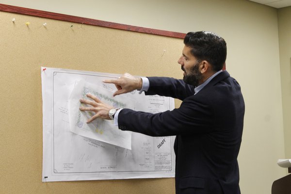 Marcus Stinchi, of Stinchi Landscaping in Westhampton Beach, shows drawings of potential designs for the soon-to-be-renovated Glover Park. KYLE CAMPBELL