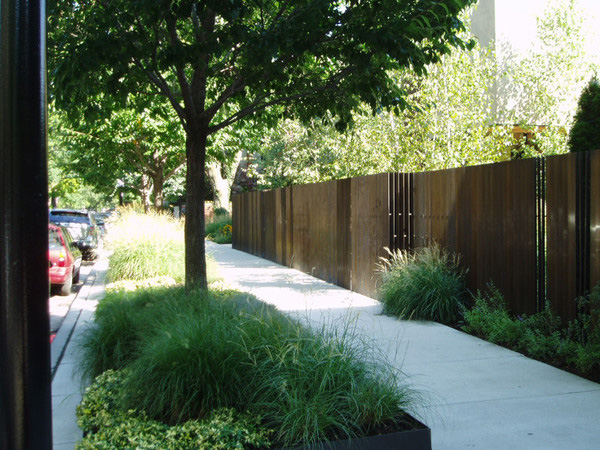The raised bronze planters outside the fence have plantings that match the interior garden.