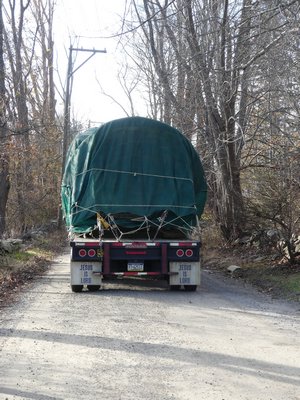 The tree arrives upstate and is backed down an unpaved road to gain access to the driveway while traffic is diverted. ANDREW MESSINGER