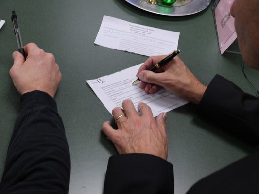 Writing out an "Energy Prescription" during an efficiency seminar at the Hampton Bays Public Library. COURTESY GORDIAN RAACKE