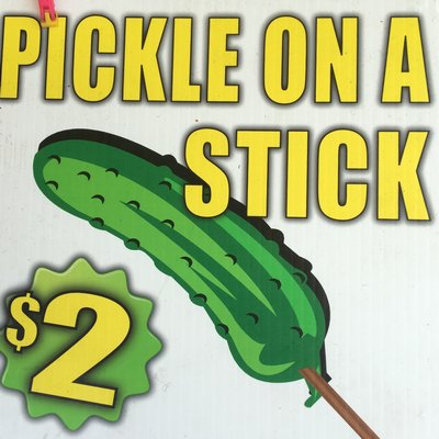 A farmer’s market vendor advertises $2 pickles on a stick.  HANNAH SELINGER
