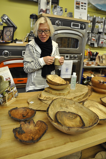 Sybille van Kempen, co-owner of Loaves & FIshes Cookshop, shows off bowls carved out of fallen trees.