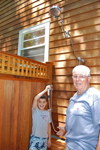 Frank Mezzacappa and Michael Mezzacappa, Jr. with their outdoor shower in Springs.  Dawn Watson