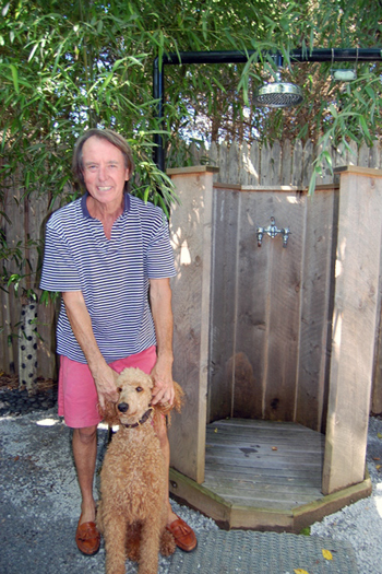 Ron Race and his dog, Sophie, by their outdoor shower in Water Mill.  Dawn Watson