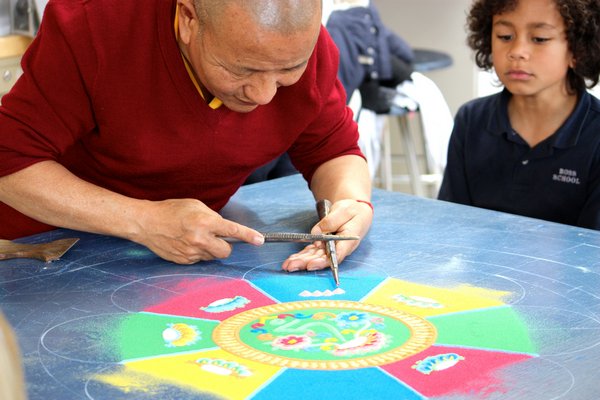 Lama Tenzin demonstrates how to create a mandala with sand. CORTNEY PROPPER